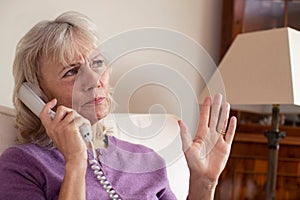 Senior Woman Receiving Unwanted Telephone Call At Home photo