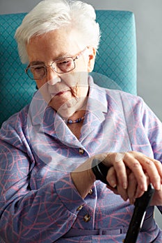 Unhappy Senior Woman Sitting In Chair