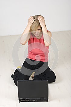 Unhappy senior woman using laptop