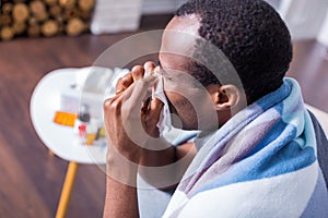 Unhappy sick man holding a paper tissue