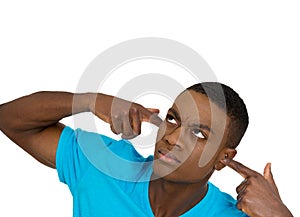 Unhappy stressed man covering his ears looking up