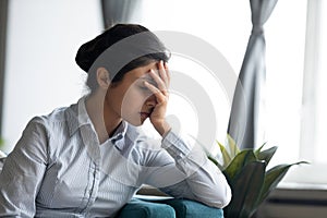 Unhappy stressed millennial indian ethnicity woman hiding face in hands.