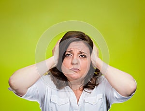 Unhappy stressed woman covering ears looking up