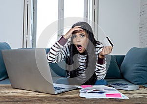 Unhappy stressed young female angry with credit card bill calculating home finance and paying bills