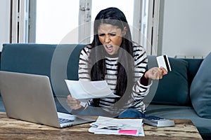 Unhappy stressed young female angry with credit card bill calculating home finance and paying bills