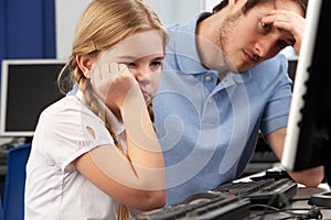 Unhappy teacher and girl using computer in class