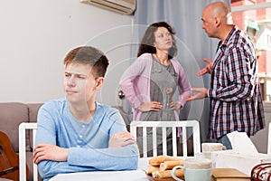 Unhappy teen boy with quarreling parents