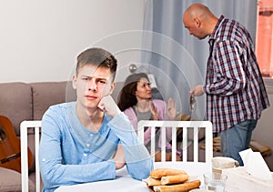 Unhappy teen boy with quarreling parents