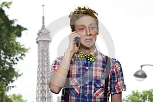 Unhappy teen boy talking on cell phone outdoor.