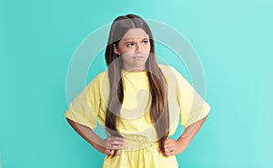 unhappy teen girl with long hair on blue background, sadness