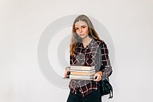 Unhappy teen girl student in college or university with stack of books white background