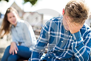 Unhappy Teenage Couple Having Argument In Urban Setting