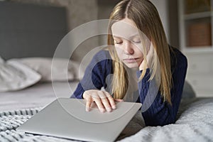 Unhappy Teenage Girl Closing Laptop Lying On Bed At Home Anxious About Social Media Online Bullying photo