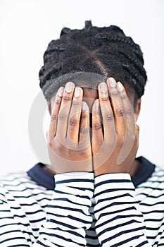 Unhappy Teenage Girl Covering Face With Hands Against White Background