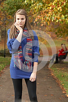 Unhappy Teenage Girl Standing In Autumn Park