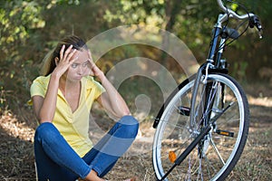 Unhappy teenage girl using bike photo