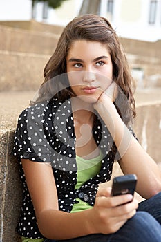 Unhappy Teenage Student Sitting Outside