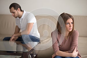 Unhappy thoughtful woman tired of quarrelling, upset man sitting