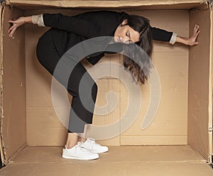 Unhappy unemployed business woman trying to increase her cramped office