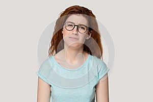 Unhappy upset face expressions redhead woman isolated on grey background