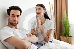 Unhappy Wife Pleading Offended Indifferent Husband For Forgiveness Indoor