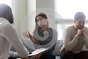 Unhappy wife talking with male counselor at family therapy session photo