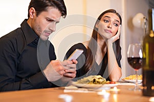Unhappy Woman Bored On Date, Man Using Phone