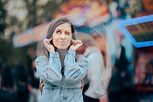 Unhappy Woman Bothered by Loud Music at Noisy Outdoors Funfair