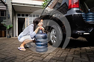 Unhappy woman carrying a gallon of water