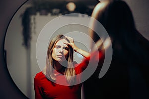 Unhappy Woman Checking her Forehead Wrinkles in the Mirror