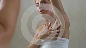 Unhappy woman checking skin on armpit, bad depilation, irritation and wrinkles