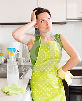 Unhappy woman cleaning furniture