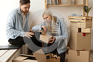 Unhappy woman client dissatisfied by parcel, looking in open cardboard damaged box, crushed fragile goods, bad delivery