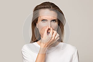 Unhappy woman close nose avoid bad unpleasant smell photo