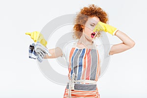 Unhappy woman closing nose by hand and holding dirty rag