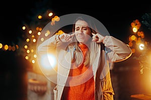 Unhappy Woman Covering her Ears Because of Christmas Songs