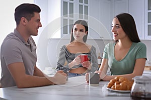 Unhappy woman feeling jealous while couple spending time together in kitchen