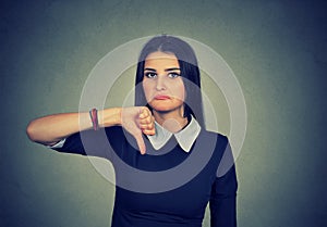 Unhappy woman giving thumb down gesture looking with disapproval