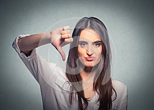 Unhappy woman giving thumb down gesture looking with negative expression