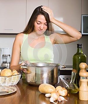 Unhappy woman preparing exotic food with rank odour