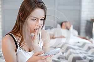 Unhappy woman reading her mans messages