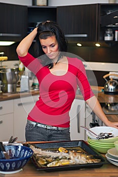 Unhappy woman standing in kitchen