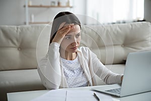 Unhappy woman stressed by slow internet connection on laptop