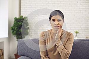 Unhappy woman suffering from acute toothache or cheek swelling after tooth extraction