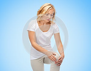 Unhappy woman suffering from pain in leg