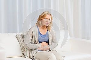 Unhappy woman suffering from stomach ache at home