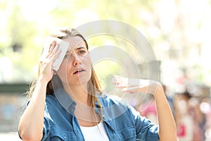 Unhappy woman sweating suffering a heat stroke photo