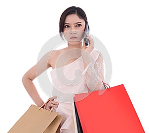 Unhappy woman talking on smartphone and holding shopping bags is