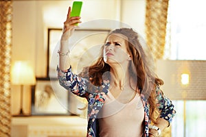 Unhappy woman trying to get better wifi signal on smartphone photo