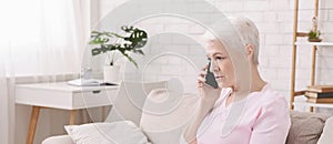 Unhappy worried senior woman talking on phone